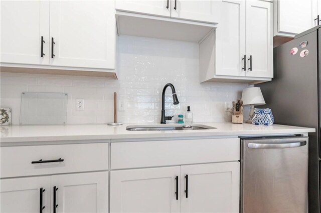 kitchen with a sink, white cabinets, dishwasher, and light countertops