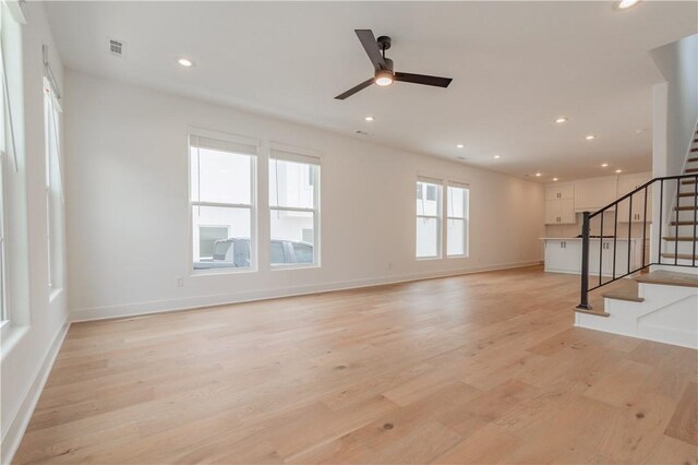 unfurnished living room with recessed lighting, visible vents, stairway, light wood-type flooring, and baseboards