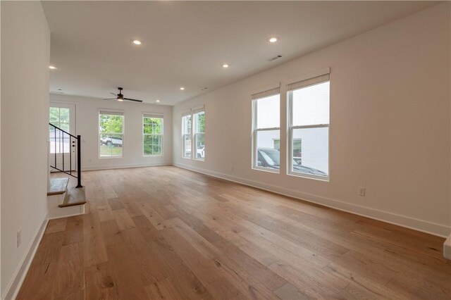 unfurnished living room featuring stairs, light wood-type flooring, visible vents, and recessed lighting