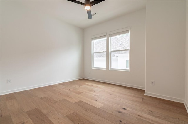 empty room with a ceiling fan, baseboards, visible vents, and light wood finished floors