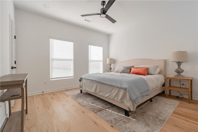 bedroom with a ceiling fan, light wood-style flooring, and baseboards