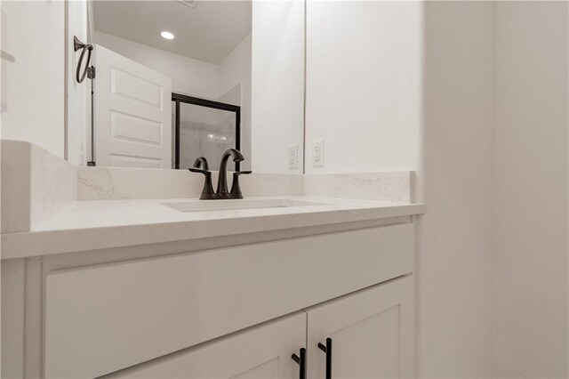 bathroom with recessed lighting, vanity, and a shower stall