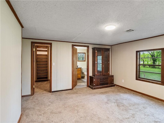 spare room featuring visible vents, carpet flooring, and crown molding