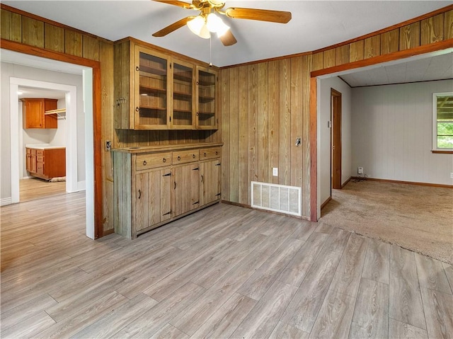 bar featuring visible vents, baseboards, ceiling fan, and wooden walls
