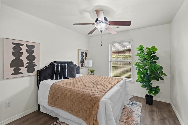 bedroom featuring wood finished floors, baseboards, and a ceiling fan