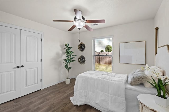 bedroom with dark wood-style floors, a closet, ceiling fan, and baseboards