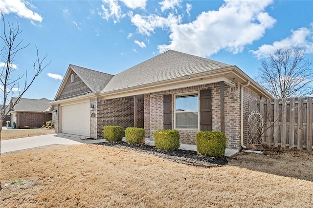 view of home's exterior featuring brick siding, fence, an attached garage, and concrete driveway
