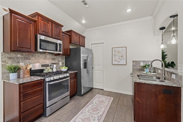 kitchen with appliances with stainless steel finishes, a sink, tasteful backsplash, light stone counters, and ornamental molding