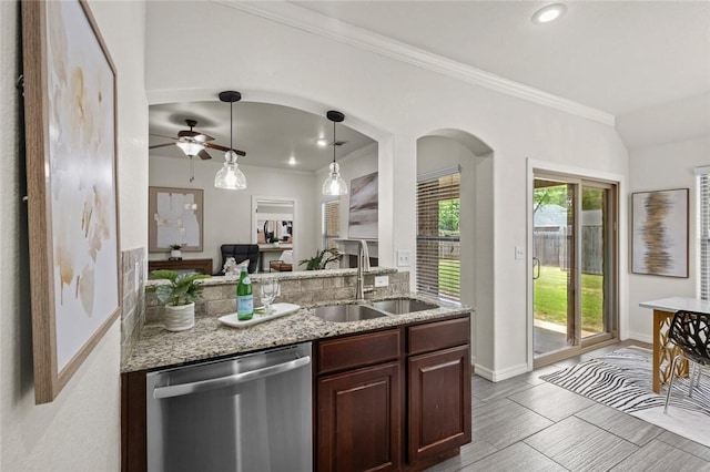 kitchen with stainless steel dishwasher, a sink, ceiling fan, light stone countertops, and crown molding