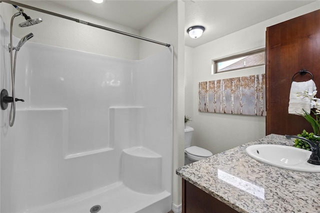full bath featuring a shower, vanity, and toilet