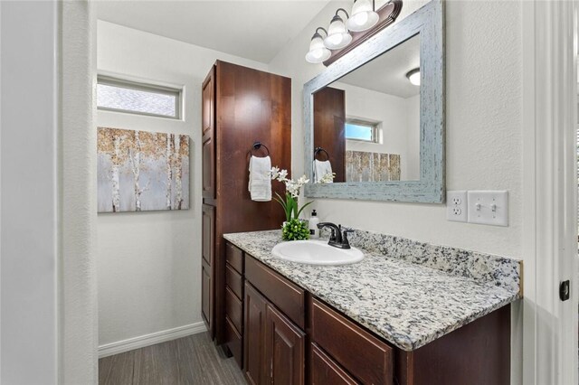 bathroom with vanity, baseboards, and wood finished floors
