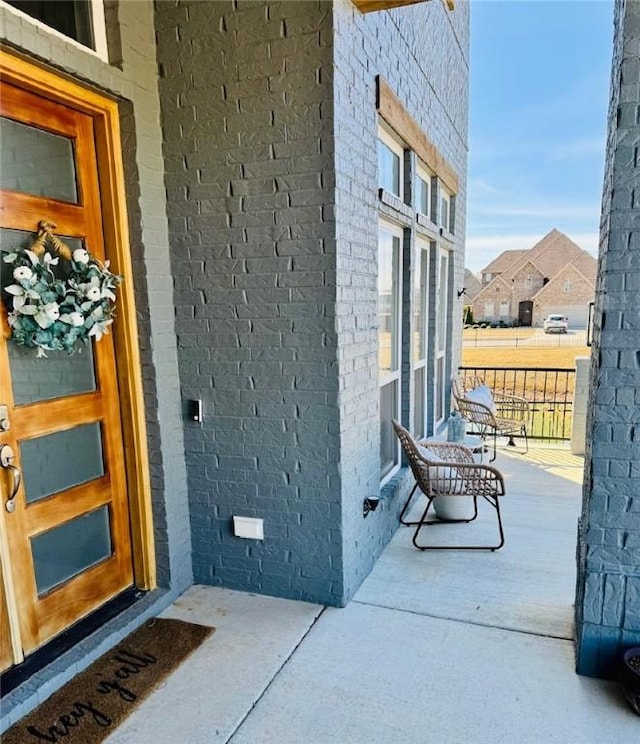 entrance to property featuring covered porch and brick siding