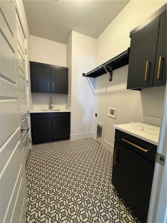 laundry area with washer hookup, cabinet space, hookup for an electric dryer, a sink, and baseboards