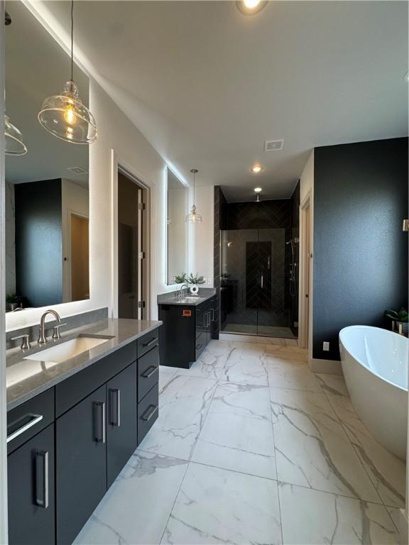 bathroom with two vanities, a sink, a freestanding bath, marble finish floor, and a shower stall