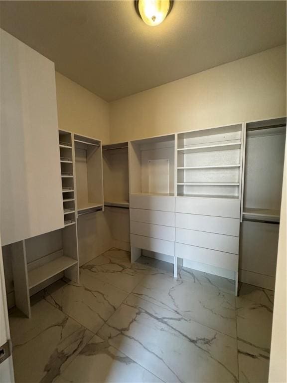 spacious closet with marble finish floor