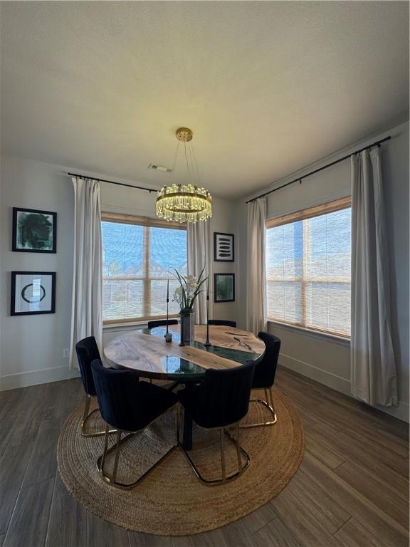 dining room featuring an inviting chandelier, plenty of natural light, and dark wood-style flooring