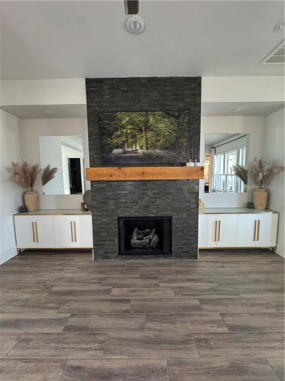 living room featuring a large fireplace and wood finished floors