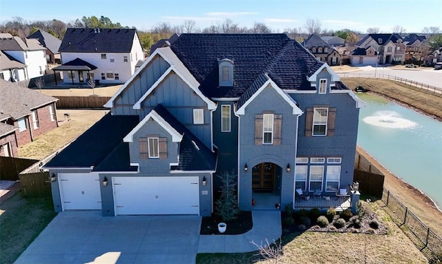 traditional-style house featuring driveway, a garage, a residential view, fence, and board and batten siding