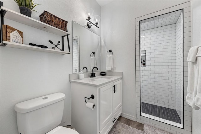 full bath featuring vanity, a shower stall, toilet, and wood finished floors