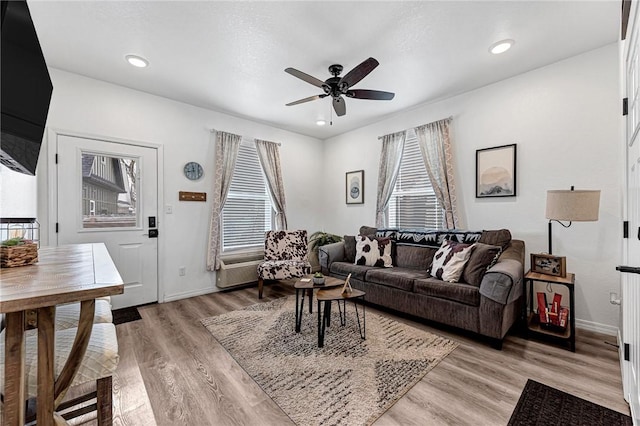 living room with light wood finished floors, recessed lighting, baseboards, and ceiling fan