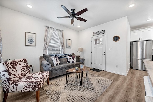 living room featuring recessed lighting, baseboards, a ceiling fan, and light wood finished floors