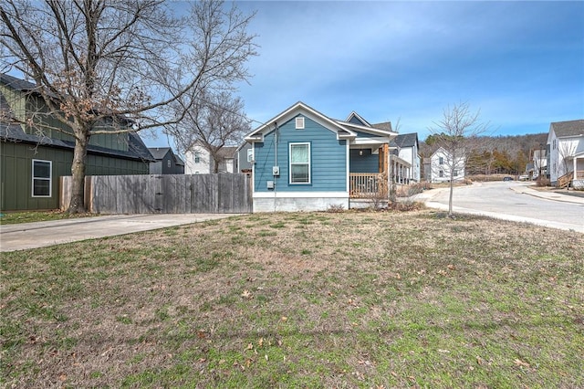 view of front of home with a front lawn, fence, and a residential view