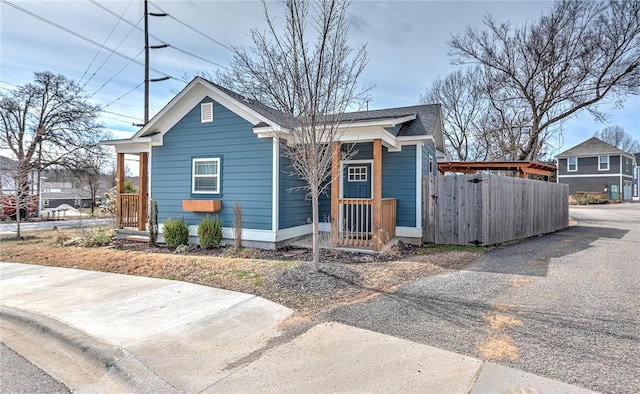 bungalow-style house with roof with shingles and fence