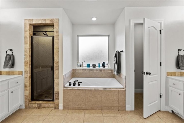 bathroom with tile patterned flooring, a shower stall, a bath, and vanity