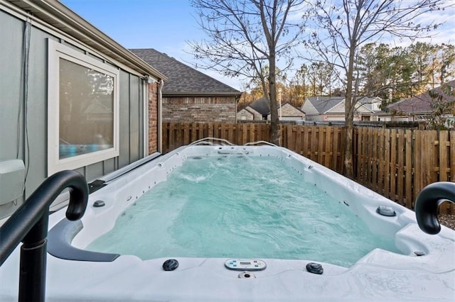 exterior space with fence and a hot tub