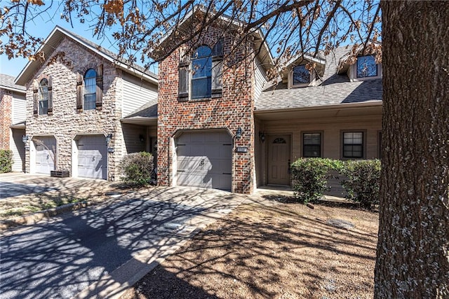 view of front of property featuring a garage, concrete driveway, brick siding, and a shingled roof