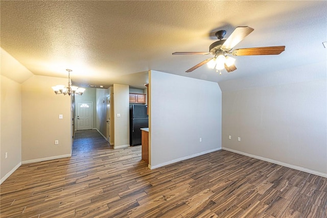 unfurnished room featuring dark wood-style floors, vaulted ceiling, a textured ceiling, and ceiling fan with notable chandelier