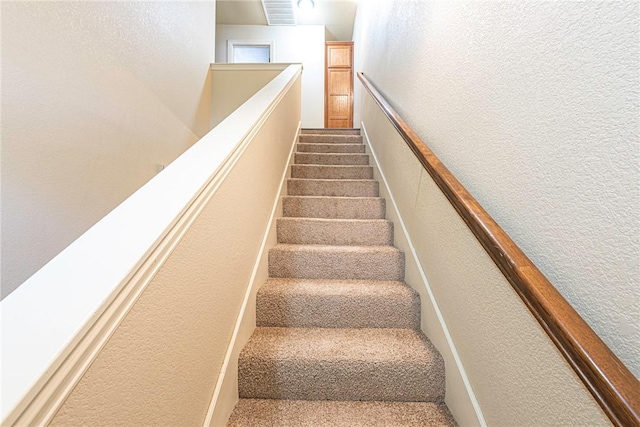 stairs with a textured wall and visible vents