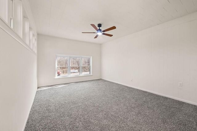 carpeted empty room with a ceiling fan and baseboards