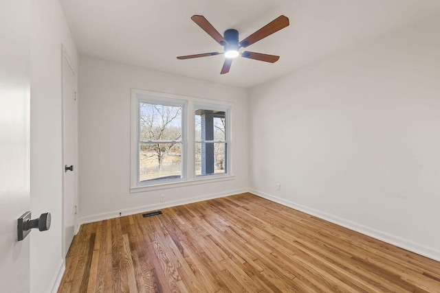 empty room featuring light wood-style floors, baseboards, visible vents, and a ceiling fan