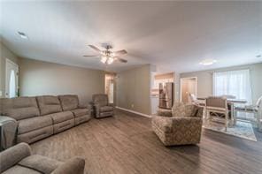 living area featuring a ceiling fan and baseboards