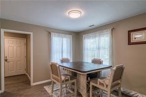 dining space featuring wood finished floors and baseboards