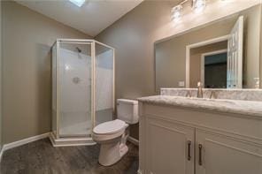 bathroom with lofted ceiling, a stall shower, vanity, and toilet