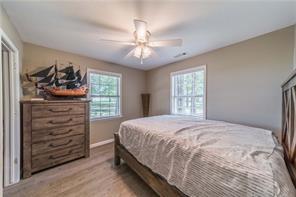 bedroom with light wood finished floors, baseboards, and a ceiling fan