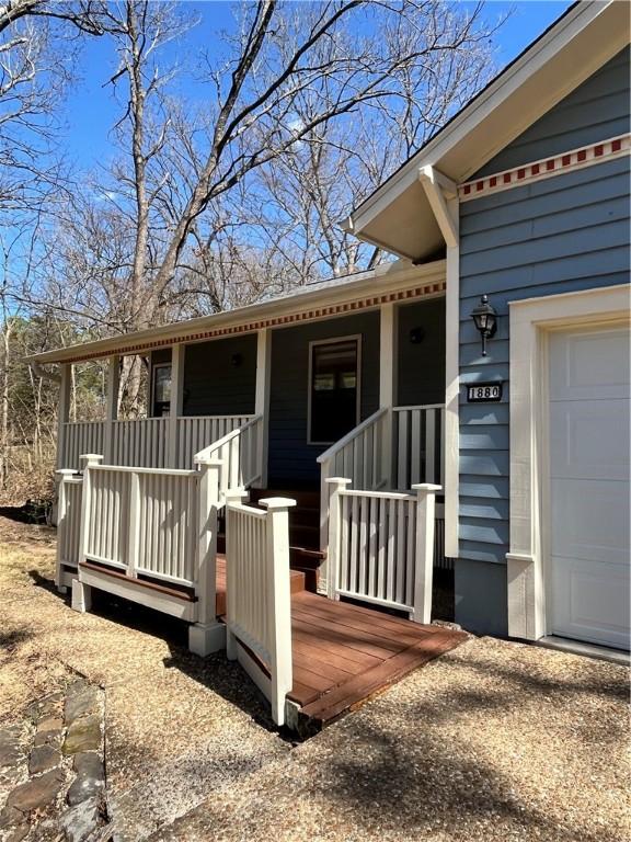 doorway to property featuring a porch and a garage