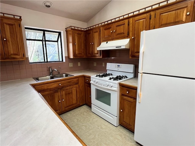 kitchen featuring brown cabinets, light countertops, a sink, white appliances, and under cabinet range hood