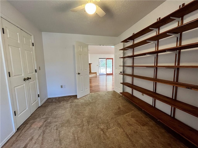 interior space featuring ceiling fan, a textured ceiling, and baseboards