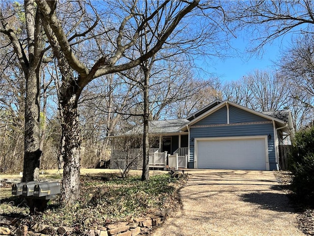 ranch-style home with dirt driveway, covered porch, and a garage