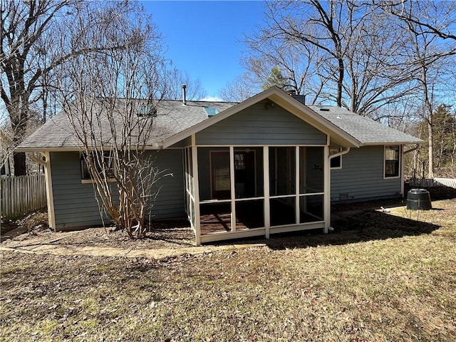 back of property featuring a yard, a sunroom, fence, and a shingled roof