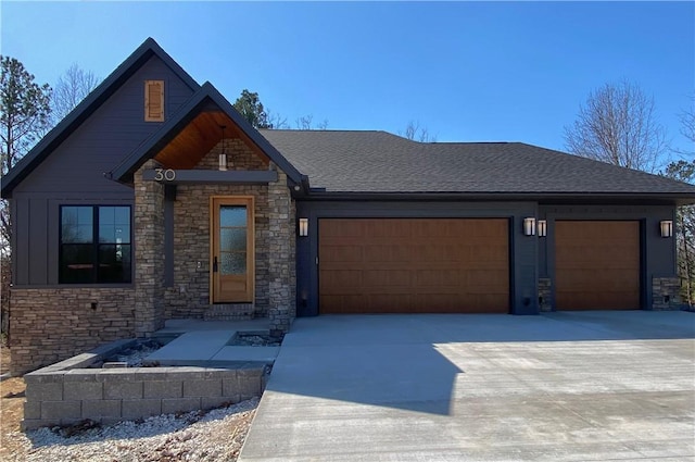 view of front facade with concrete driveway, an attached garage, and a shingled roof