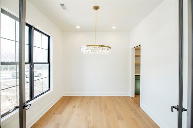 unfurnished dining area with light wood-type flooring, visible vents, baseboards, and recessed lighting