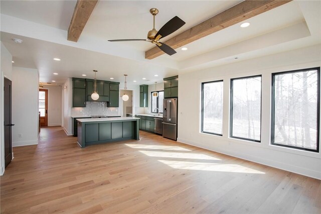 kitchen with green cabinetry, light countertops, light wood-style floors, appliances with stainless steel finishes, and beamed ceiling