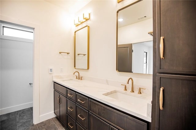 bathroom featuring double vanity, visible vents, baseboards, and a sink