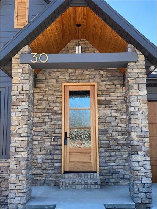 view of exterior entry featuring stone siding