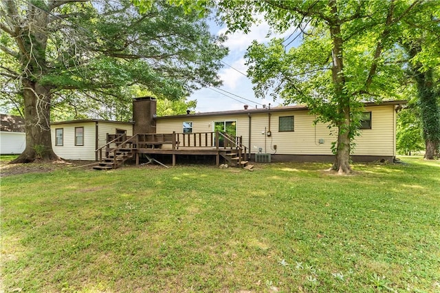 back of property with a chimney, central AC unit, a lawn, and a wooden deck