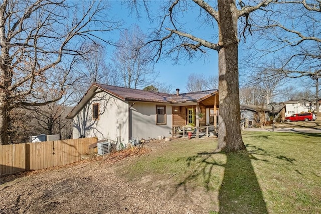 view of front facade with metal roof, a front lawn, and fence